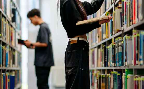 Students looking through books in the library