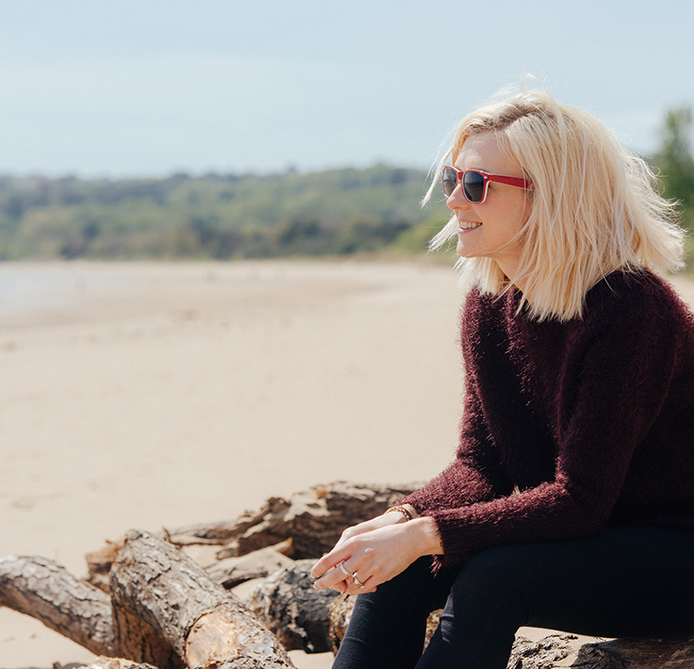 Student on the beach by the Singleton campus