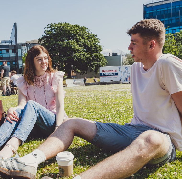 Two students on the lawn in front of Fulton House