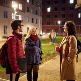 An image of three students standing outside accommodation on Bay Campus.
