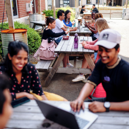 An image of students socialising together outdoors on Bay Campus. 