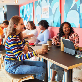 An image of students studying and chatting in a cafe on Singleton Campus. 