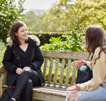 female students distancing on a bench