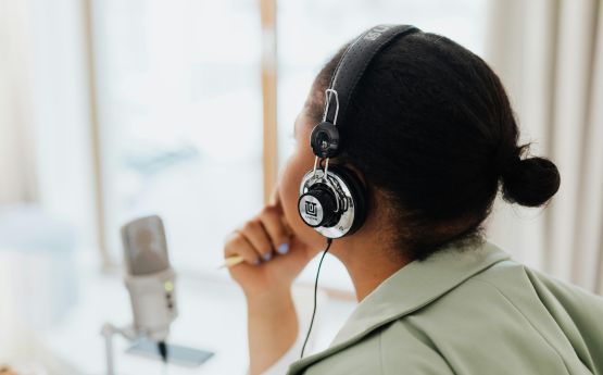 Person with headphones in front of mic