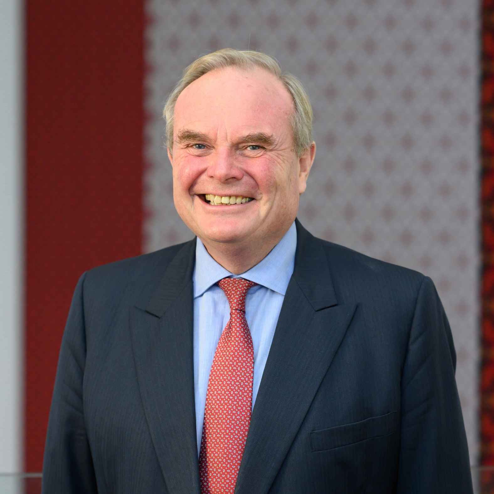 Man wearing a shirt & tie smiling at the camera