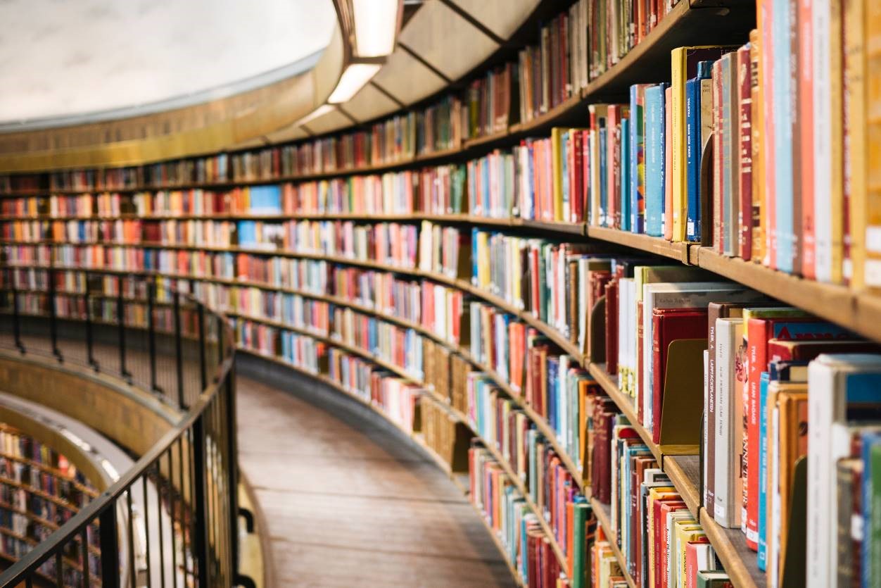 Shows a curving bookcase in a library. 