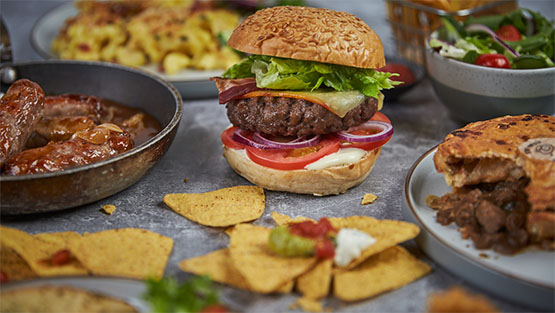 juicy beef burger and nacho crisps on a board