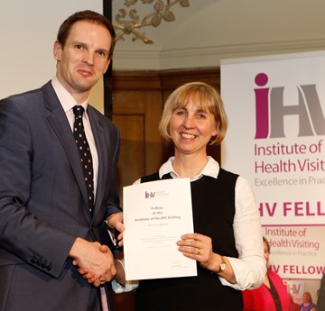 Louise receiving an award, shaking hands