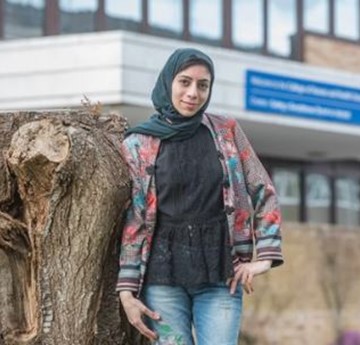 Rawan Taha stood by a large tree stump