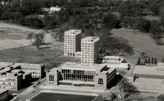 A black and white photo of College/Fulton house in front of residences