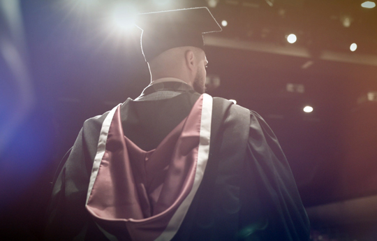The back of man in a graduation cap and gown 