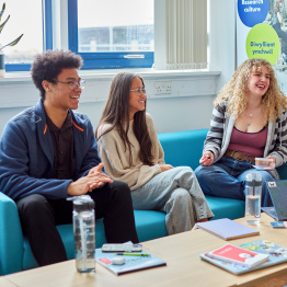 An image of three students talking to each other on campus.