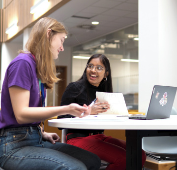An image of two students studying together on the Bay Campus.