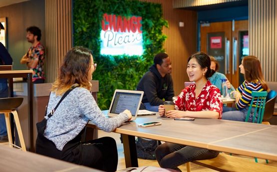 Students at a cafe with a laptop.