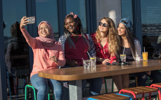 Students taking a selfie in Mumbles