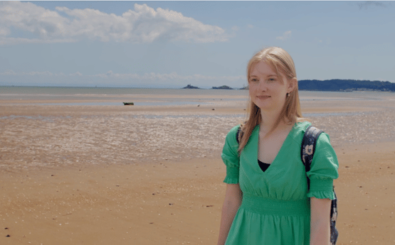 Cara, walking on a beach. 