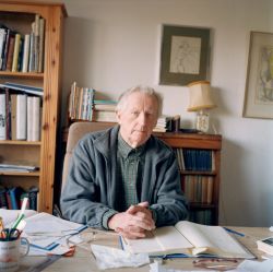 Emyr Humphreys sitting at a desk in a study