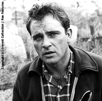 A black and white photograph of a young Richard Burton dressed in casual clothes in a cemetery - (c) Everett Collection | Rex Features