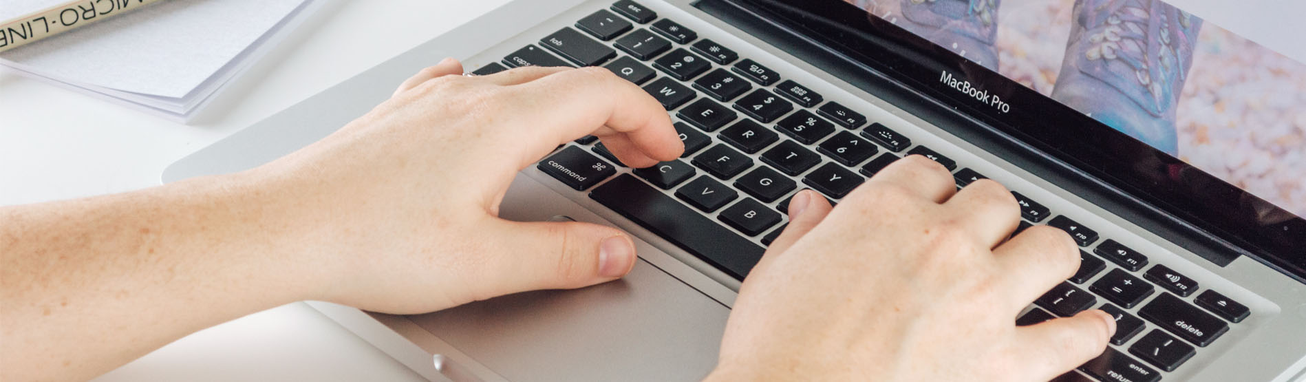 Image of a student typing on a laptop