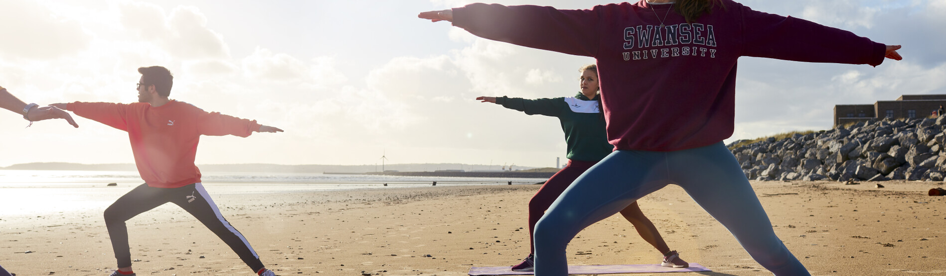 Students sitting on the beach meditating