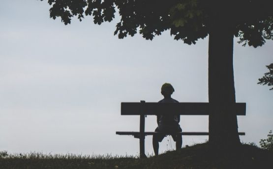 boy sitting under a tree