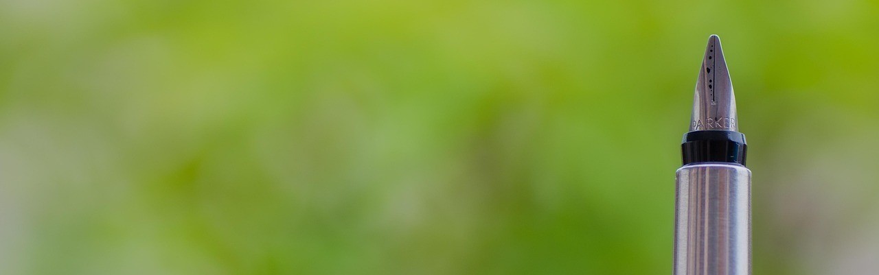 Fountain pen against green blurred background