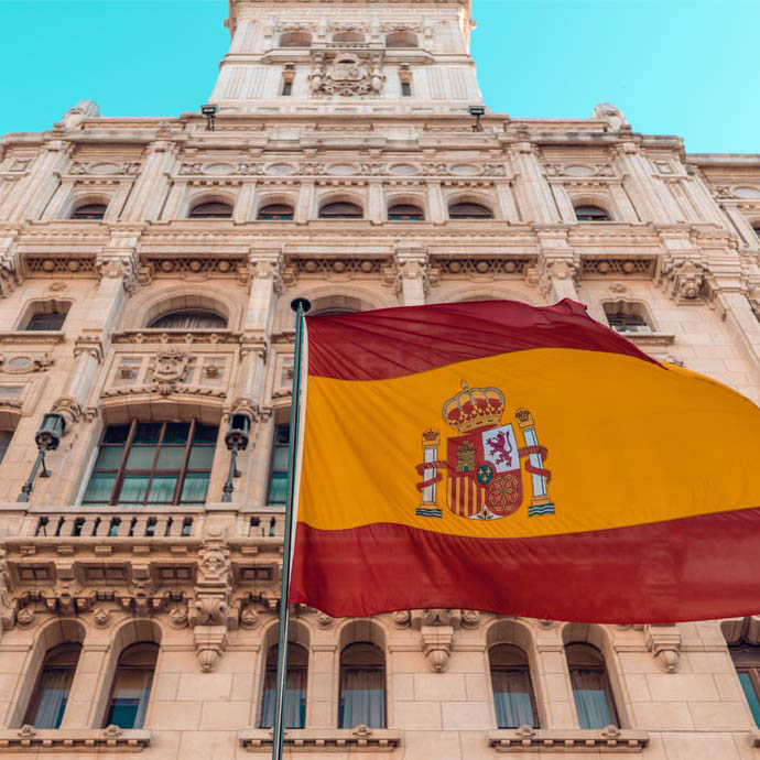 Image of a Spanish flag up in the air by the building