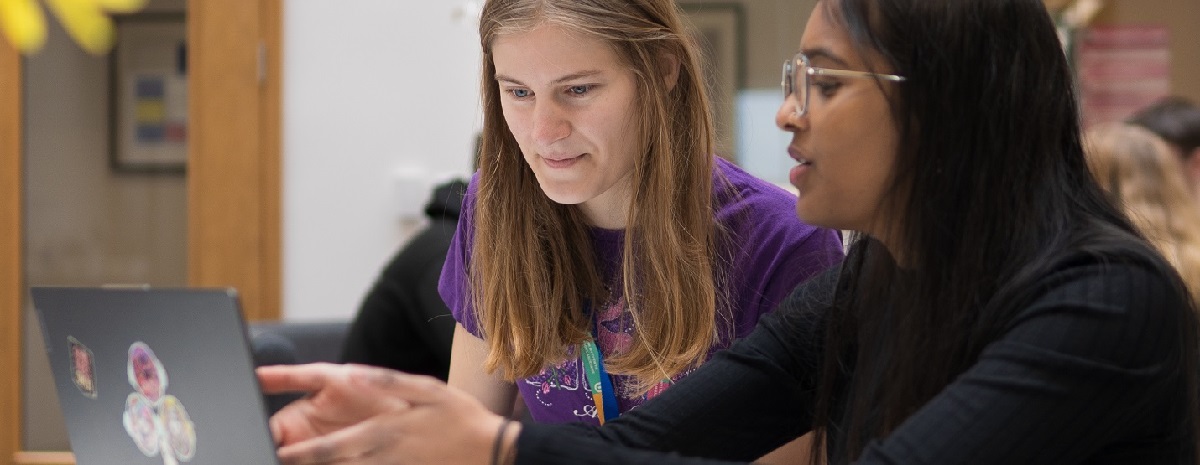 Two female students looking at a laptop