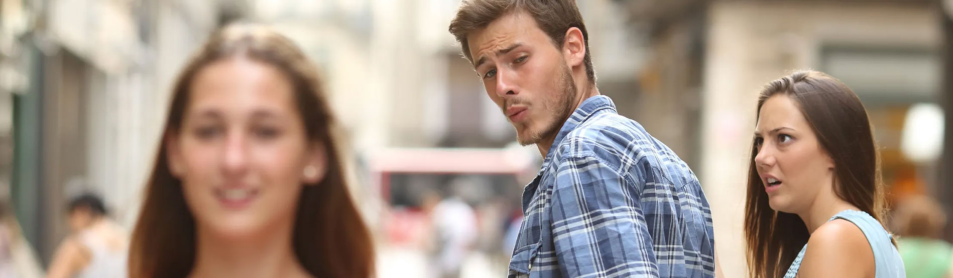 A popular meme showing the man, of a couple, looking back in appreciation of another woman who has just walked past. The female of the couple is looking less than impressed at him.