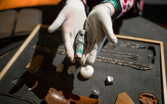 Two hands holding an Egyptian artifact 