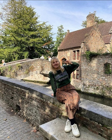 Student sat on bridge in front of building