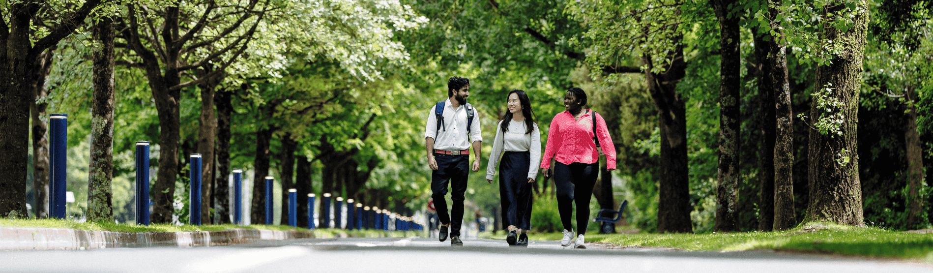 Myfyrwyr yn cerdded trwy campws. 