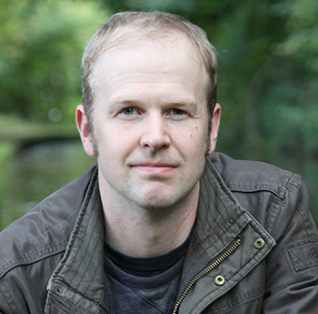 a photo of Tyler Keevil from the chest up. He is wearing a dark jacket and sweater