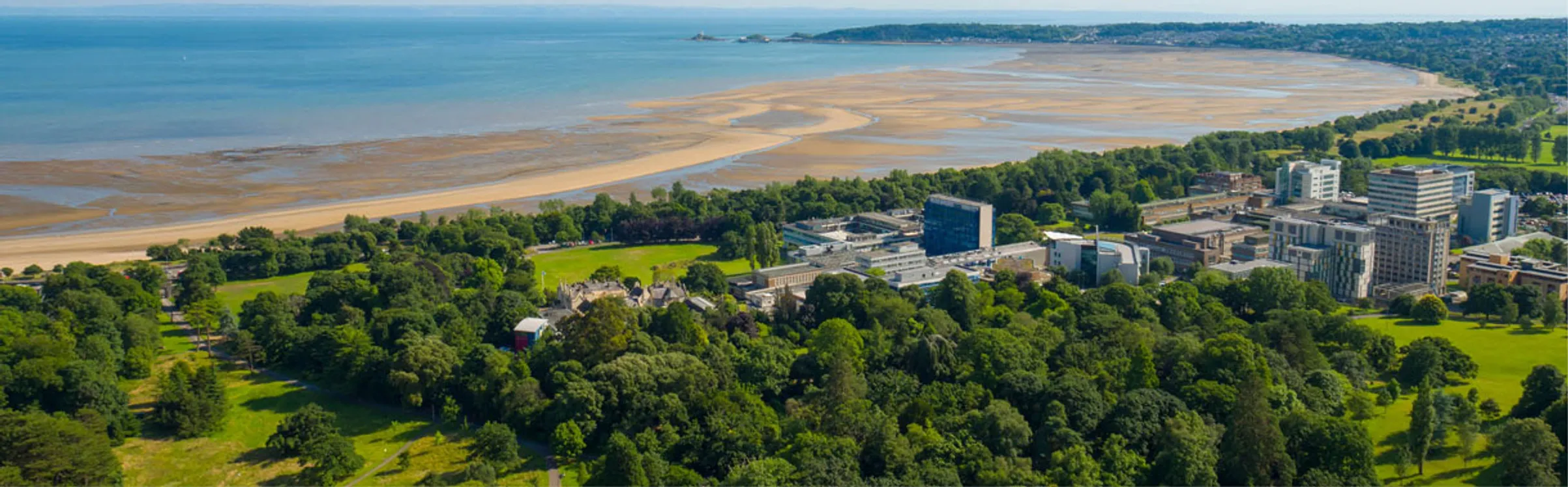Golygfa o'r awyr o gampws Singleton gyda'r môr yn y cefndir