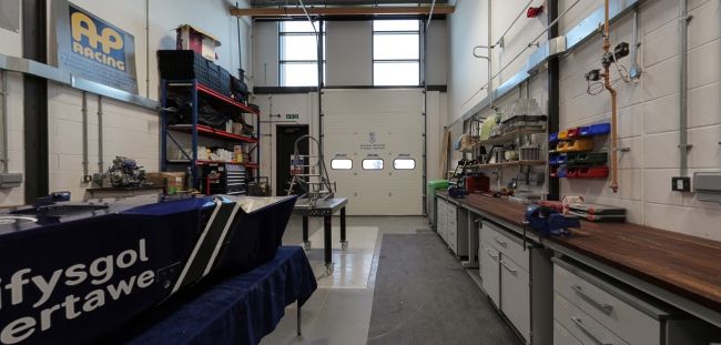Gweithdy Formula Student gyda rhannau ceir rasio, meinciau gwaith ac offer