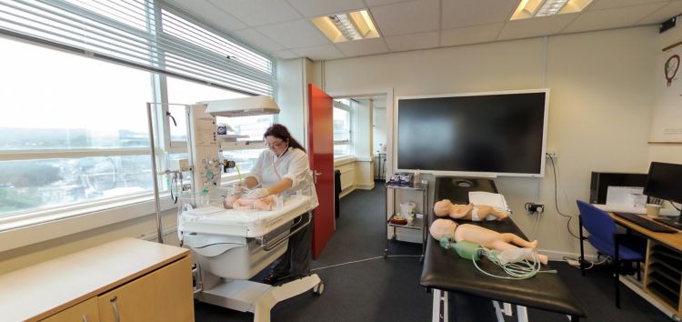 Ystafell ymarfer bydwreigiaeth gydag offer gofal newyddenedigol a modelau hyfforddi