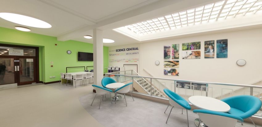 Man astudio yn Science Central gyda seddi, byrddau ac ardal atriwm agored