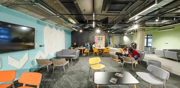 Myfyrwyr yn astudio ac yn cydweithio mewn gofod dysgu cymdeithasol modern
