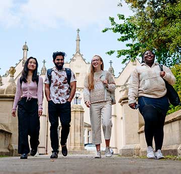 A photo of Swansea University students walking towards Singleotn park with the Abbey Building in the background