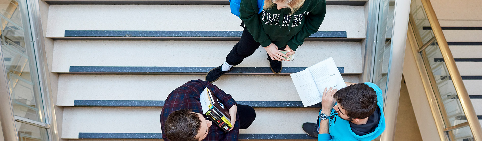 Students standing and chatting on steps.