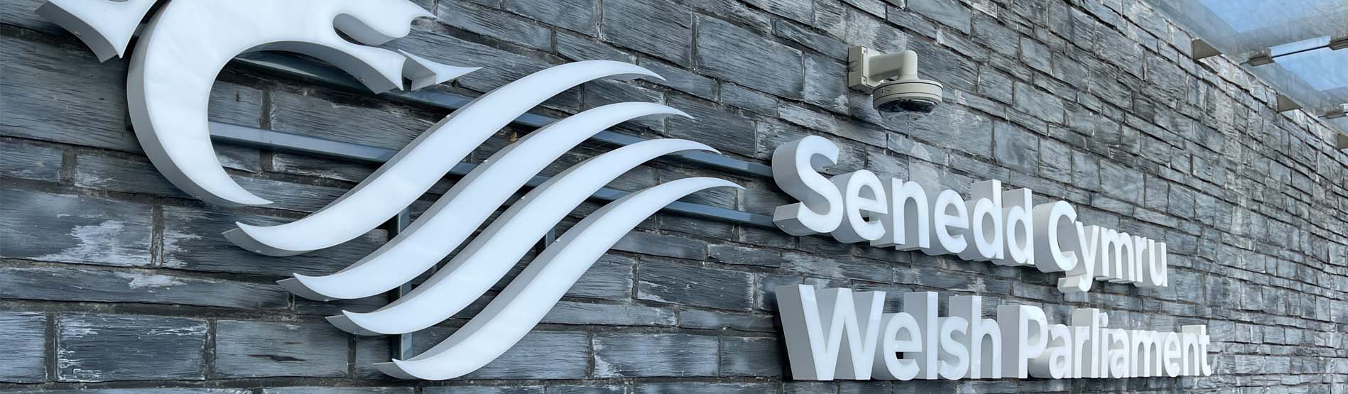 The wall of the Senedd in Cardiff with its name on