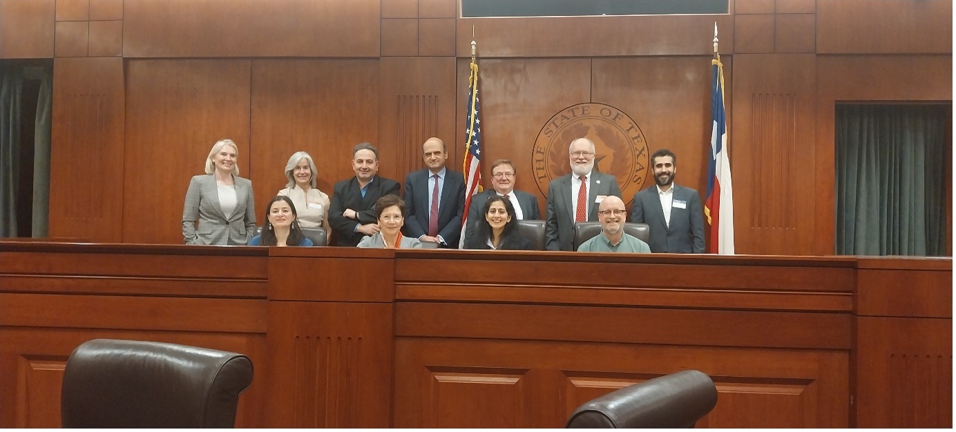 Siaradwyr a chadeiryddion yn sefyll ar ôl y digwyddiad yn y lleoliad yn Ysgol y Gyfraith Austin Prifysgol Texas