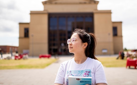 girl looking to side, a building dominates the background