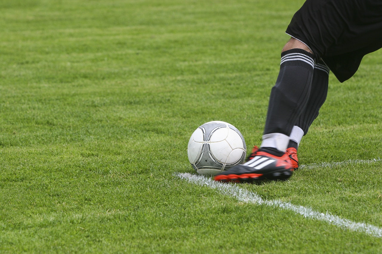 male kicking football