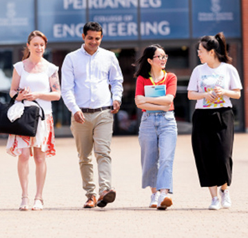 Four students walking towards the camera at Bay Campus