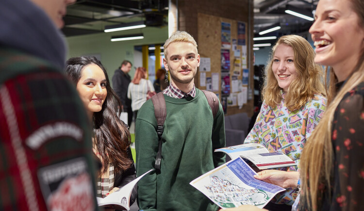 Students standing having a conversation