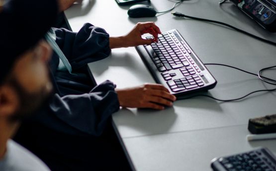 A person typing on a black keyboard