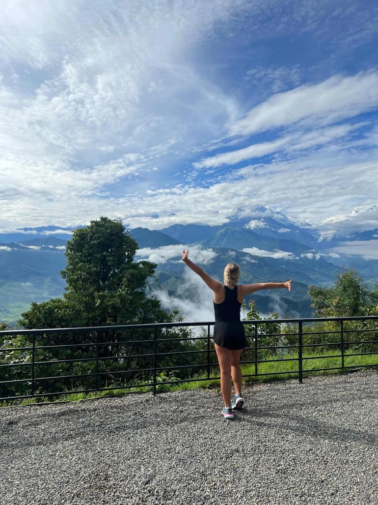 Student standing in front of mountains 