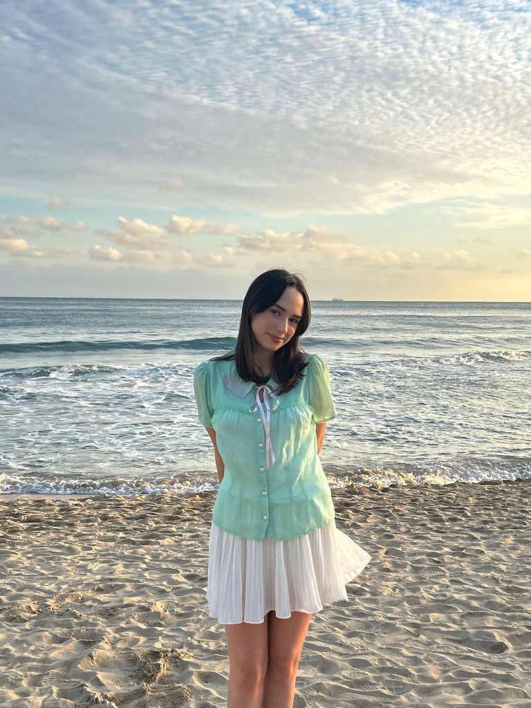 Student standing in front of ocean