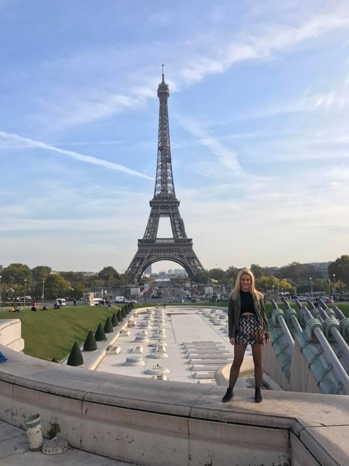 student standing in front of the Eiffel Tower
